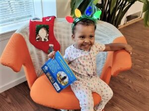 Alani celebrates Christmas in her pajamas with a lightup headband at RMHCDC.
